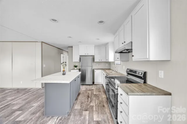 a kitchen with stainless steel appliances white cabinets and a stove top oven