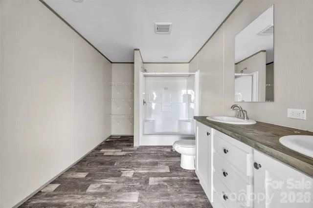 a bathroom with a granite countertop sink a mirror and a shower