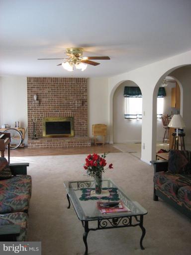 885 Crystal Rock Road Lusby, MD 20657 - Photo 4 of 18 a living room with furniture flowers and a fireplace