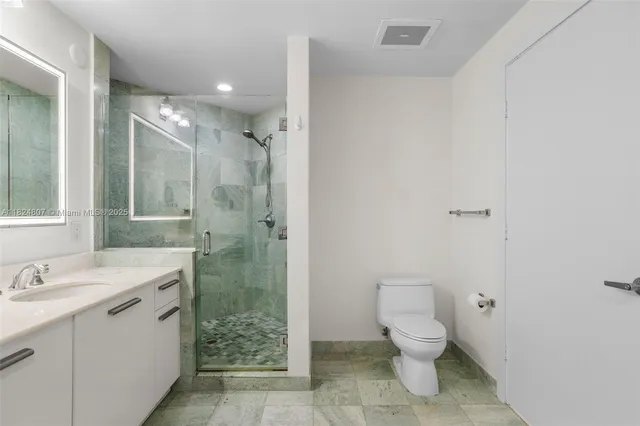 a bathroom with a double vanity sink toilet and shower