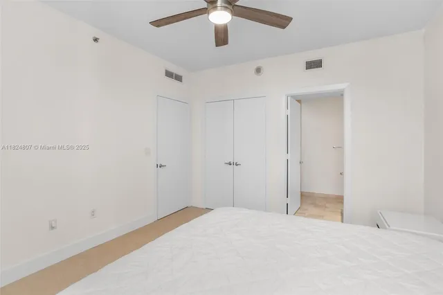 a big room with closet and a chandelier fan