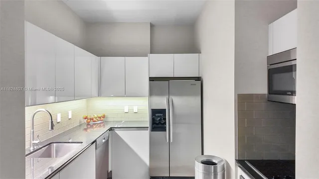 a kitchen with a refrigerator sink and cabinets