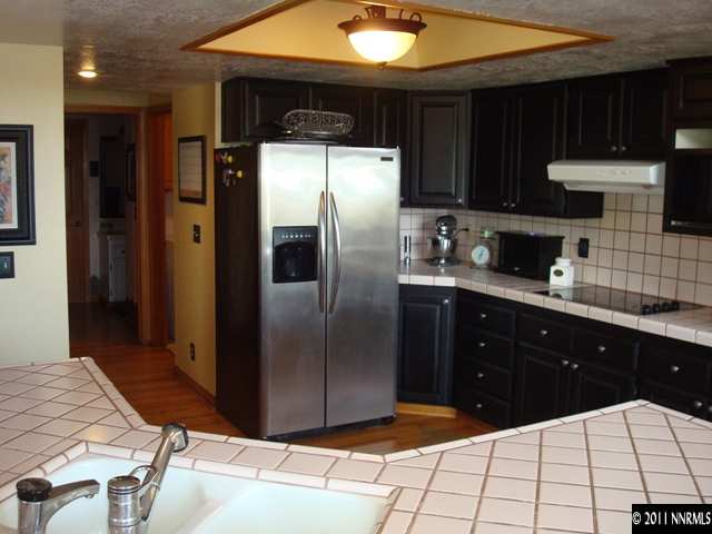 3342 Corey Drive Reno, NV 89509 - Photo 3 of 13 a kitchen with stainless steel appliances kitchen island granite countertop a refrigerator a stove a sink and dishwasher