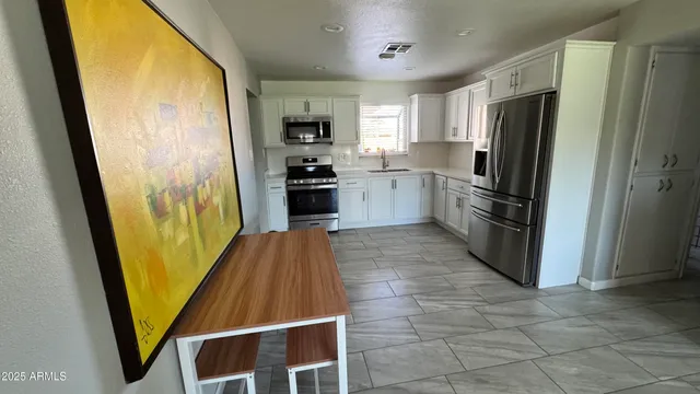 a kitchen with stainless steel appliances a refrigerator a stove top oven and a refrigerator