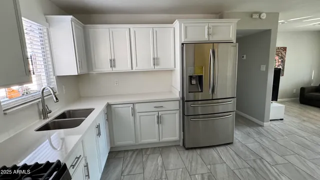 a kitchen with a refrigerator sink and cabinets