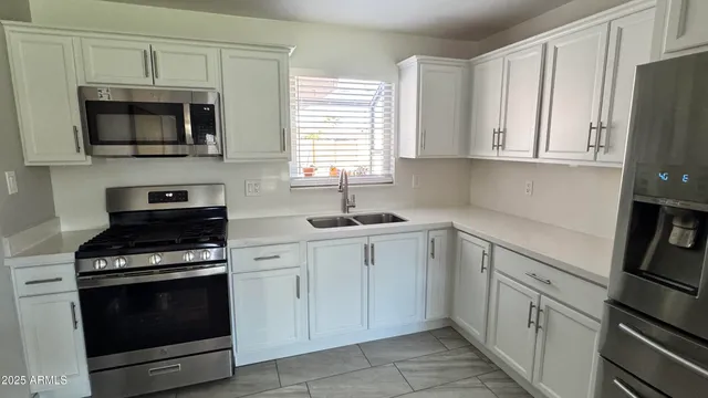 a kitchen with white cabinets and stainless steel appliances