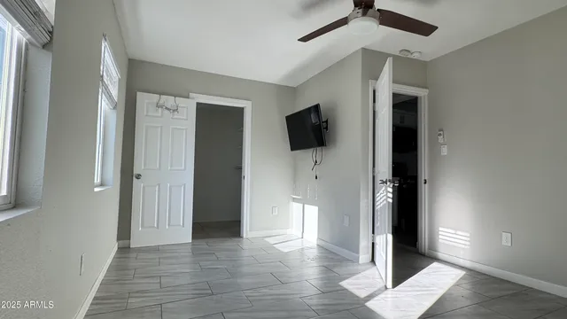 a view of a hallway with wooden floor and a bathroom