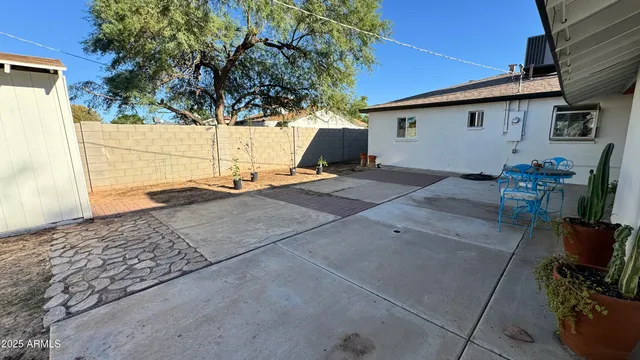 a backyard of a house with table and chairs