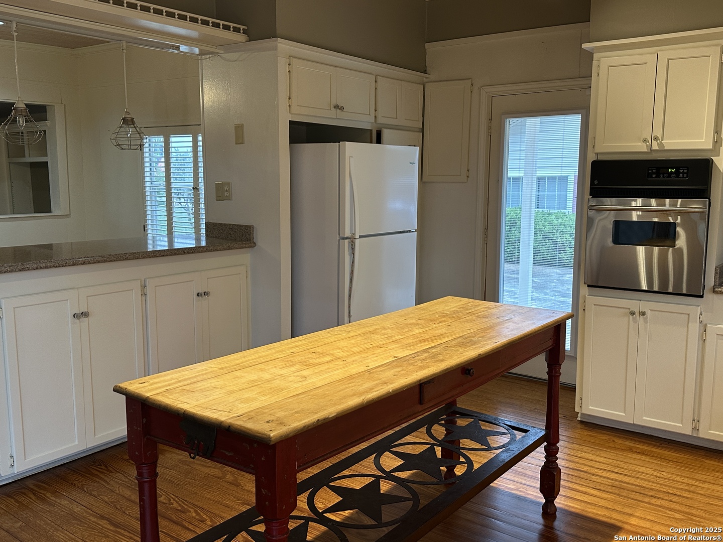 148 Robindale West Road Bandera, TX 78003 - Photo 5 of 24 a kitchen with stainless steel appliances a kitchen island a stove a refrigerator cabinets and wooden floor