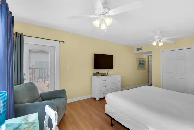 a view of a hallway with wooden floor windows and a kitchen