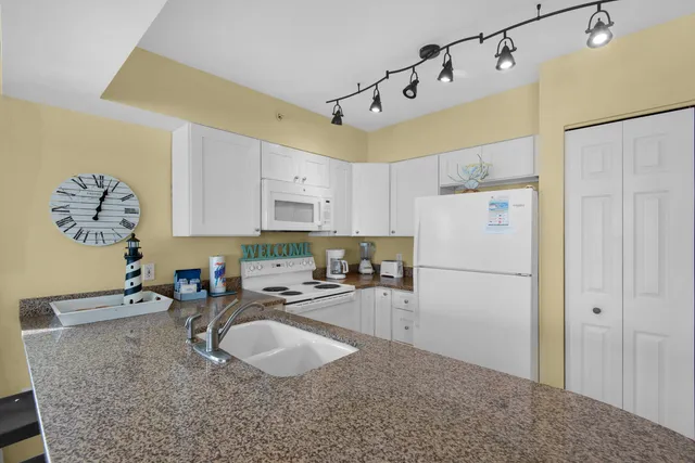 a kitchen with stainless steel appliances granite countertop a sink a refrigerator and a stove