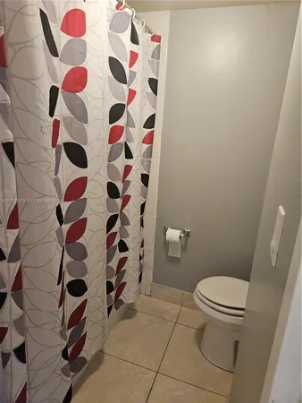 a bathroom with a toilet and a shower curtain