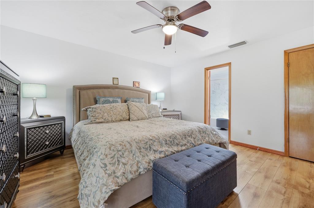 16104 Southwest 48th Circle Ocala, FL 34473 - Photo 19 of 34 a bedroom with a bed and a chandelier