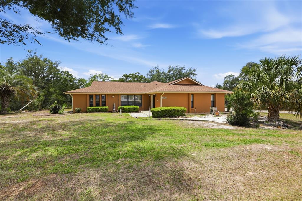16104 Southwest 48th Circle Ocala, FL 34473 - Photo 2 of 34 a front view of a house with a garden