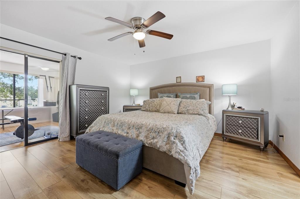 16104 Southwest 48th Circle Ocala, FL 34473 - Photo 21 of 34 a bedroom with a large bed and a chandelier