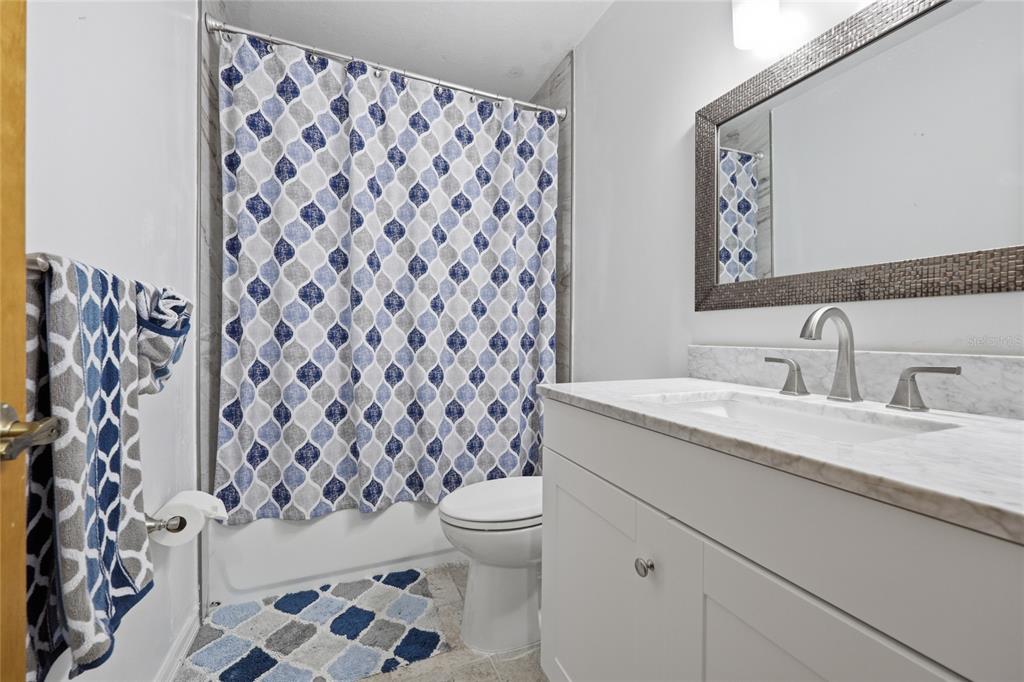 16104 Southwest 48th Circle Ocala, FL 34473 - Photo 22 of 34 a bathroom with a granite countertop sink a toilet and a mirror