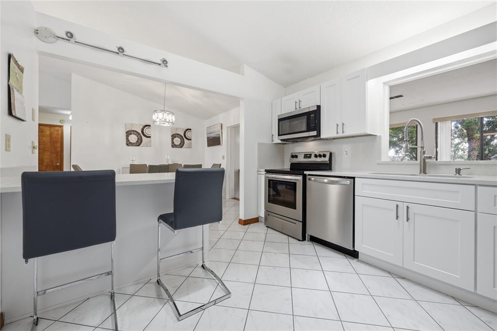 16104 Southwest 48th Circle Ocala, FL 34473 - Photo 6 of 34 a kitchen with stainless steel appliances a refrigerator sink and microwave