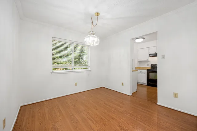 a view of a kitchen with wooden floor and a window
