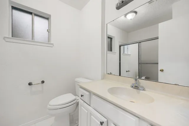 a bathroom with a sink toilet and mirror