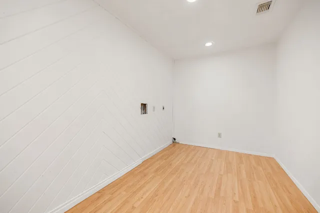 a view of a room with wooden floor and white walls