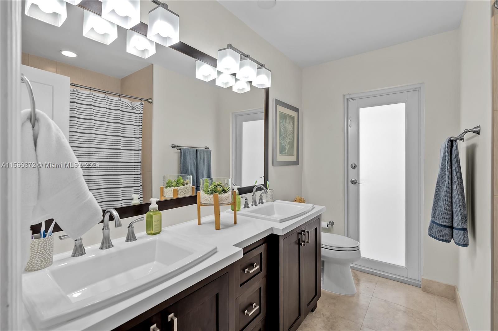 8341 Southwest 87th Terrace Miami, FL 33143 - Photo 19 of 31 a bathroom with a sink a double vanity and a mirror