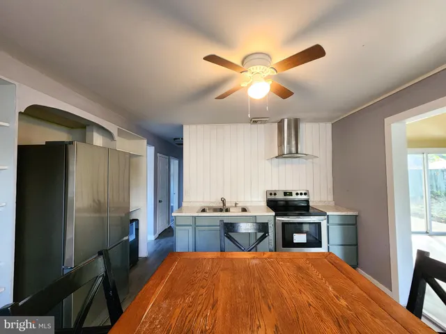 a kitchen with stainless steel appliances kitchen island granite countertop a sink a stove counter space and cabinets