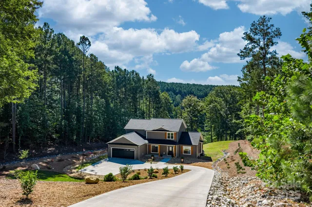 an aerial view of a house with swimming pool and garden