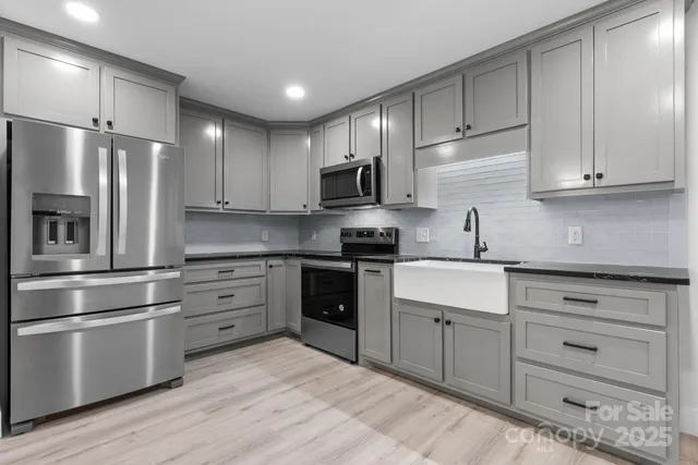 a view of an empty room and kitchen view