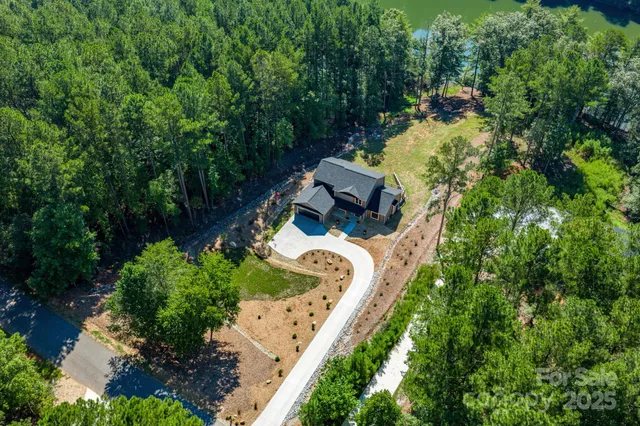 a view of a house with a lush green forest