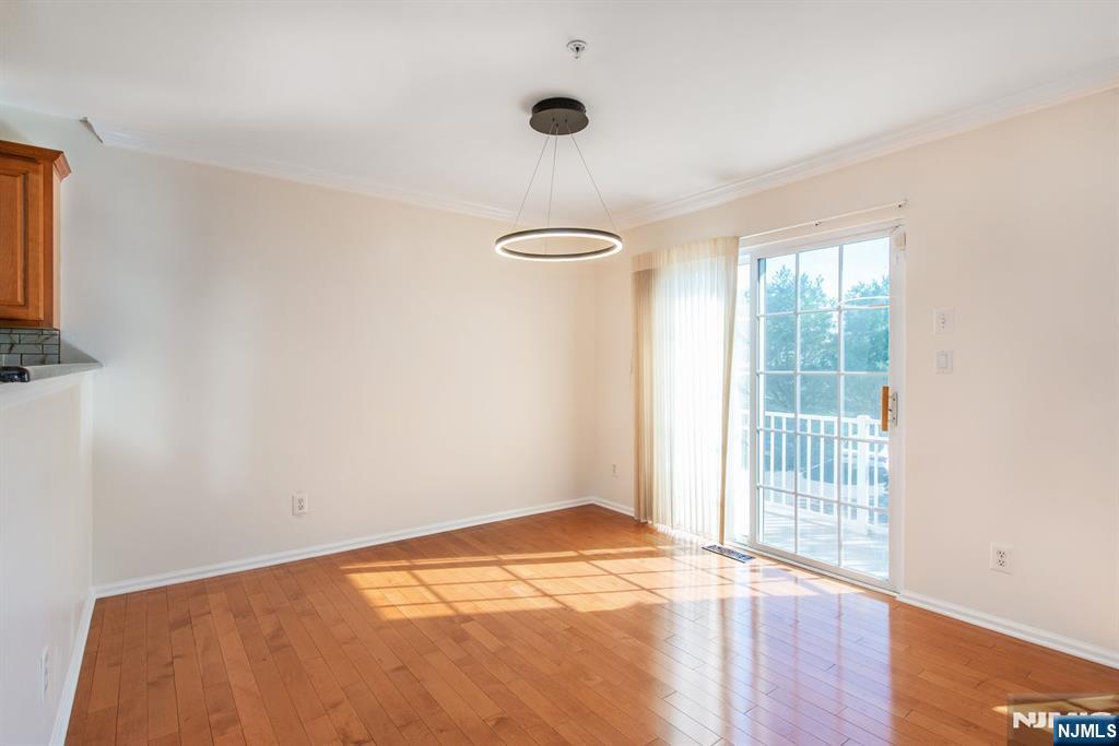 146 Summit Ridge, Unit 1406 Pompton Lakes, NJ 07442 - Photo 8 of 26 an empty room with wooden floor and windows