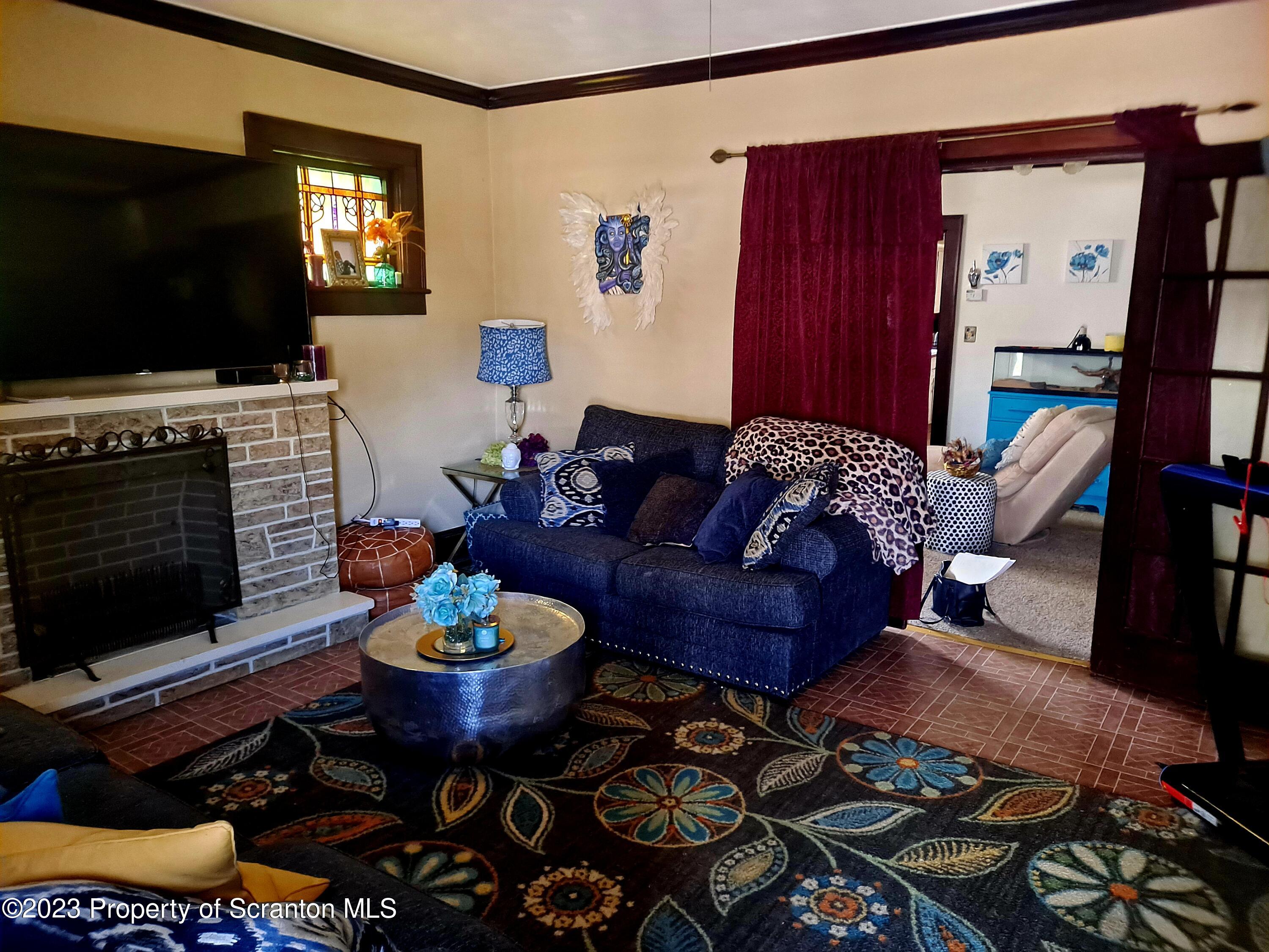 231 Putnam Street Scranton, PA 18508 - Photo 3 of 13 a living room with furniture a flat screen tv and a fireplace