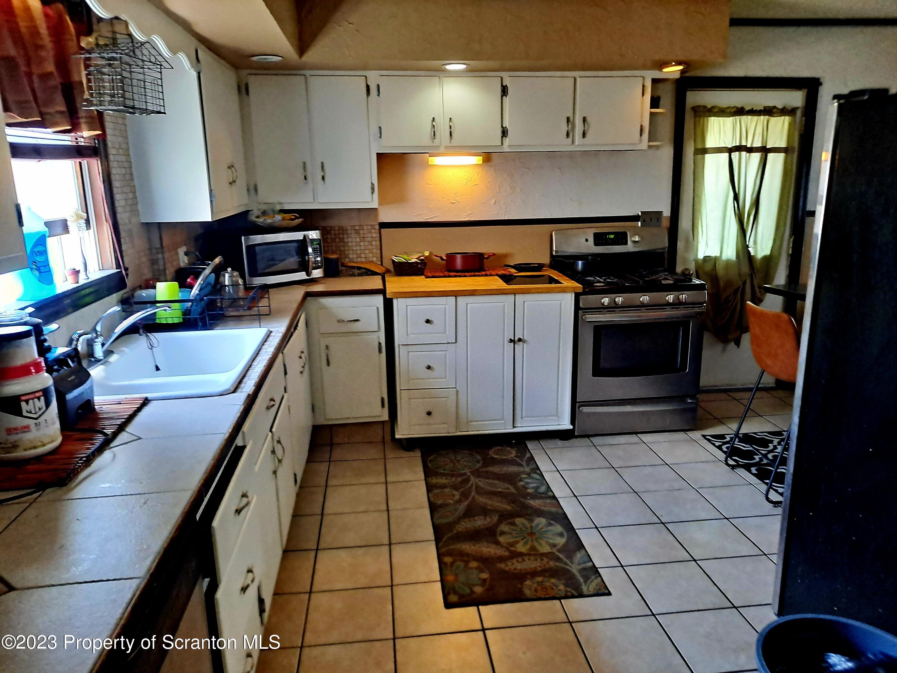 231 Putnam Street Scranton, PA 18508 - Photo 7 of 13 a kitchen with a sink a stove and cabinets