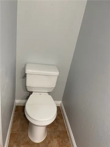 a white toilet sitting next to a white wall