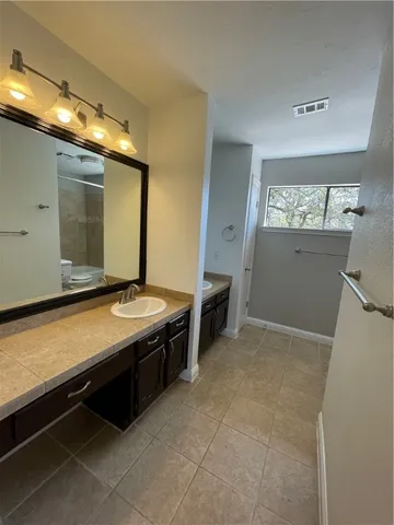 a bathroom with a granite countertop toilet a sink and a shower