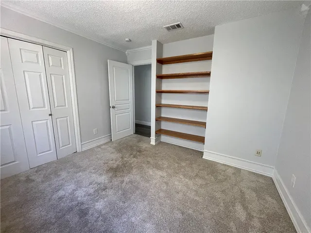 an empty room with windows and fan view