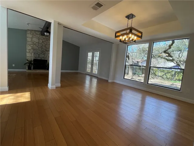 a view of a room with wooden floor chandelier and entryway