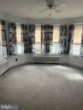 an empty room with windows and chandelier