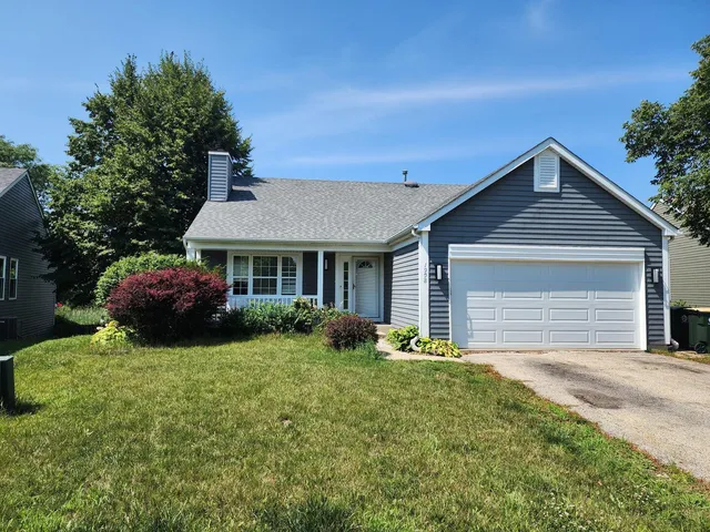 a front view of a house with yard and green space