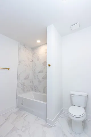 a bathroom with a toilet and a shower