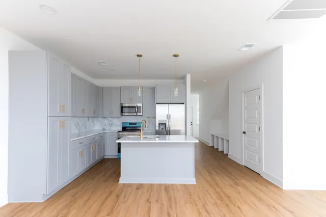 a kitchen with stainless steel appliances granite countertop a white cabinets and wooden floors