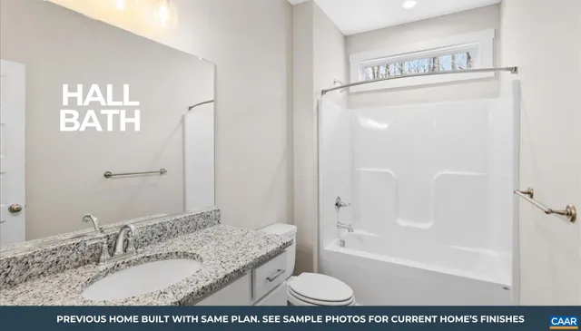 a bathroom with a granite countertop sink a mirror and a bathtub