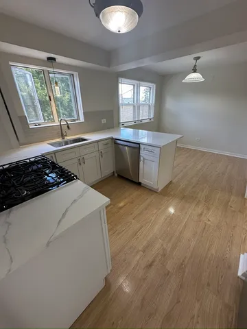 a kitchen with a stove a sink and a window