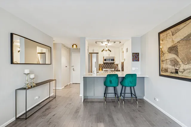 a living room with furniture and a dining table with wooden floor