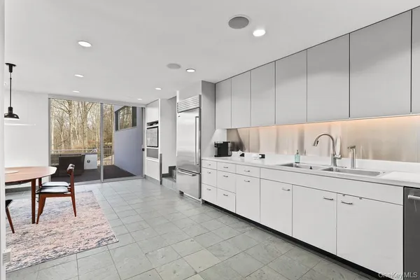 a large white kitchen with cabinets and chairs