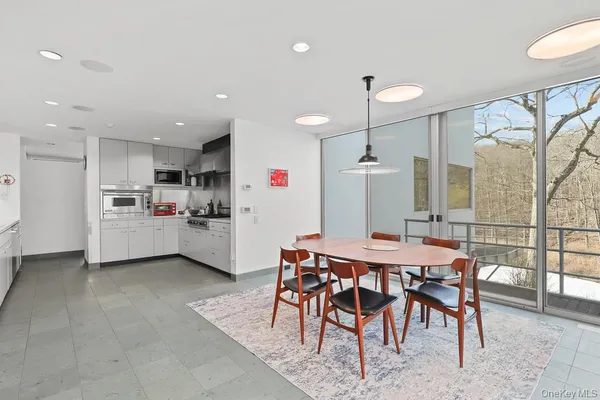 a kitchen with stainless steel appliances kitchen island granite countertop a table chairs and a refrigerator