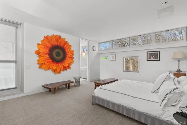 a bedroom with a bed and painting on the wall