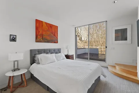 a bedroom with a bed and a lamp on dresser