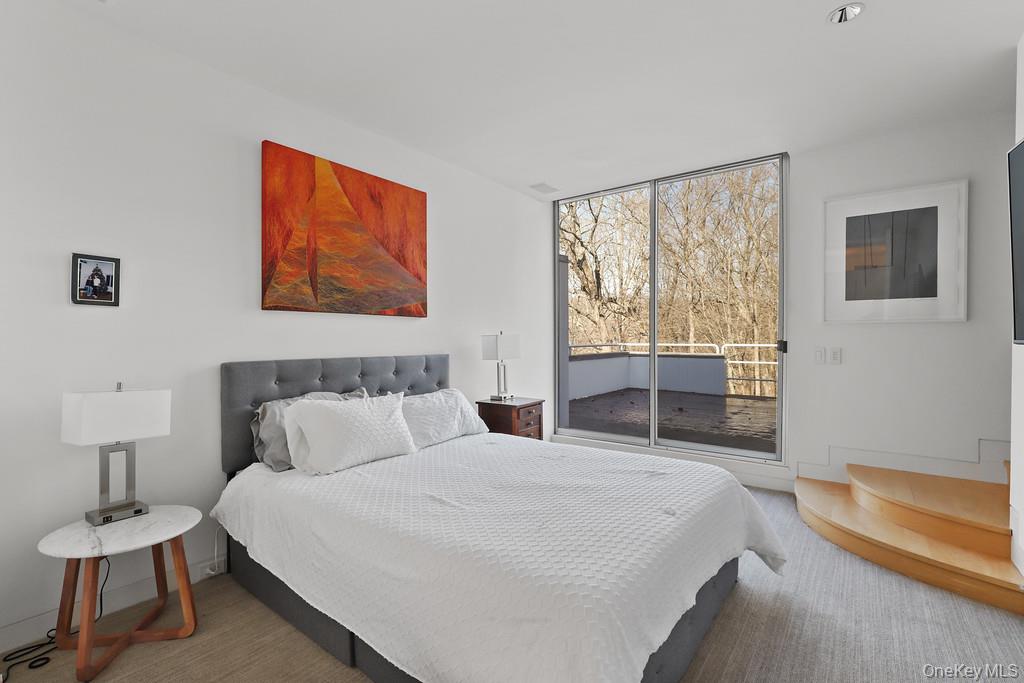 54 Cross Pond Road Pound Ridge, NY 10576 - Photo 17 of 50 a bedroom with a bed and a lamp on dresser