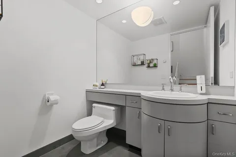 a bathroom with a toilet sink and mirror