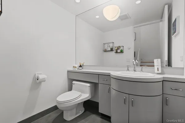 a bathroom with a toilet sink and mirror